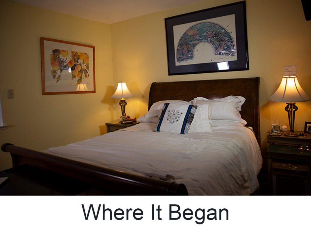 Bedroom with yellow walls and picture behind the bed